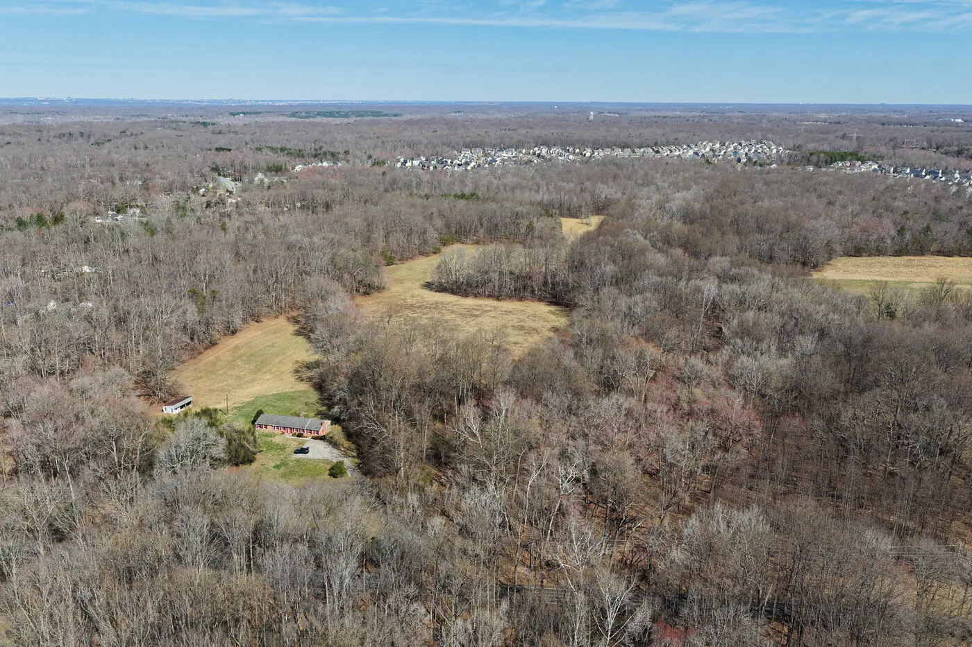 Aerial of a wooded Virginia land parcel with a homestead and treeline