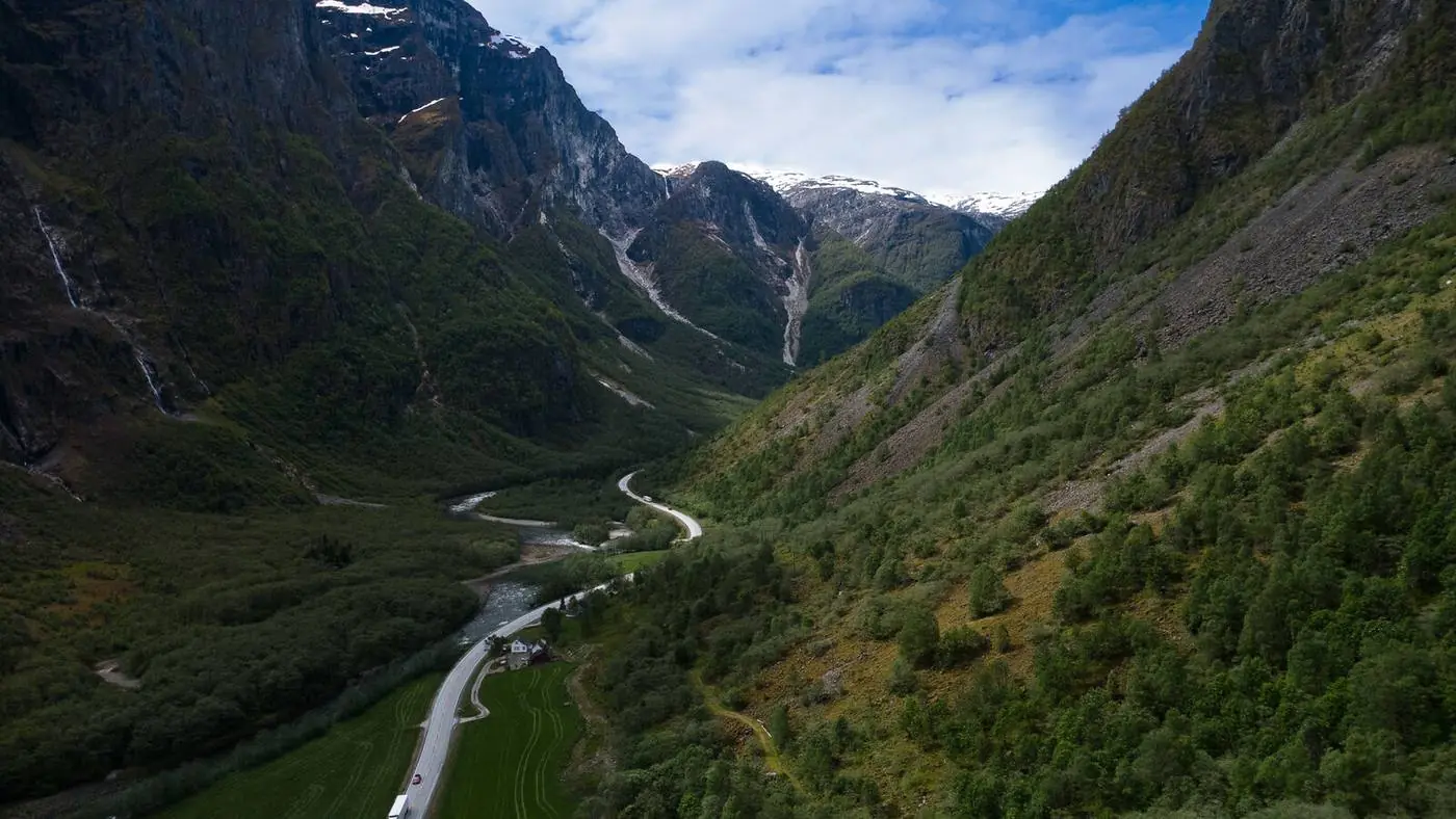 Aerial landscape photography of a green mountain valley and river in Norway