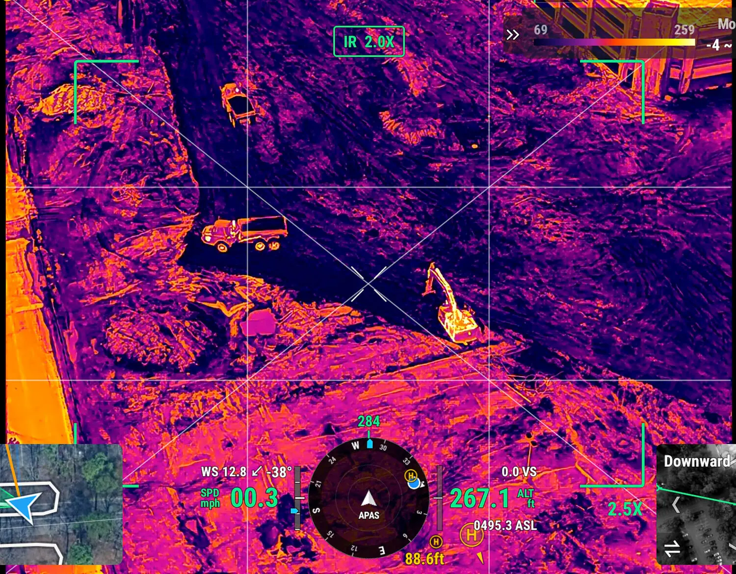 Thermal drone view of a job site showing a hot excavator and vehicles glowing against cool ground, ironbow palette